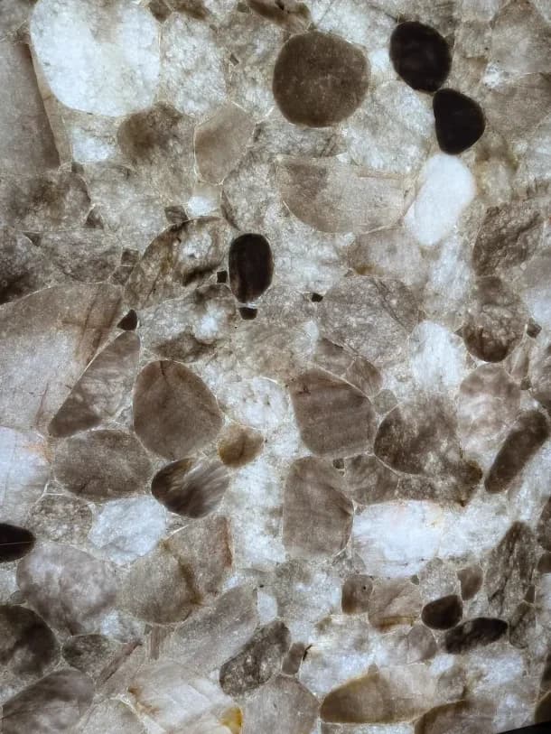 backlit white quartz with dark pebbles through it