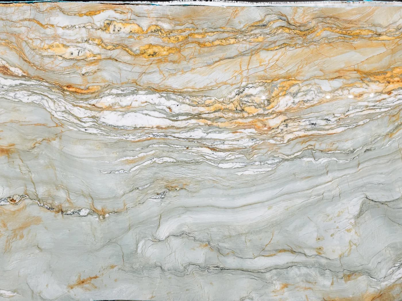 A cream quartzite slab shot through with gold and amber veining