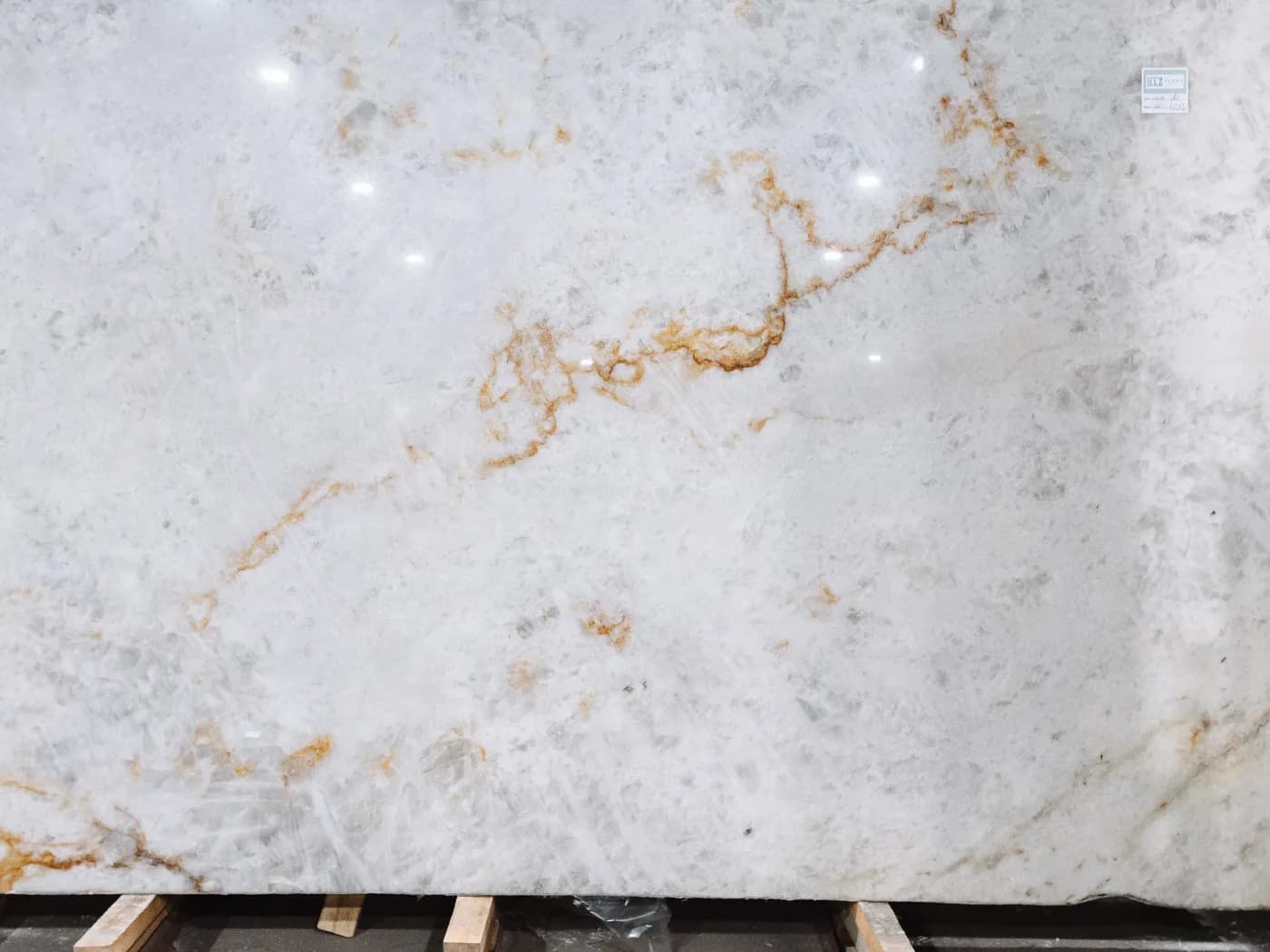 A pale white slab with fine rust-coloured veining