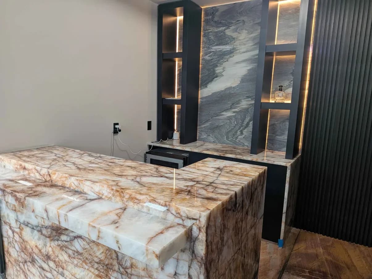 A showroom bar in veined stone with lit display shelving