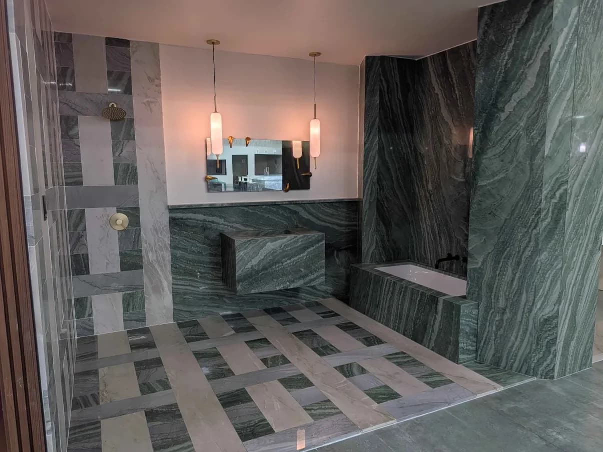 A showroom bathroom clad floor to ceiling in green stone