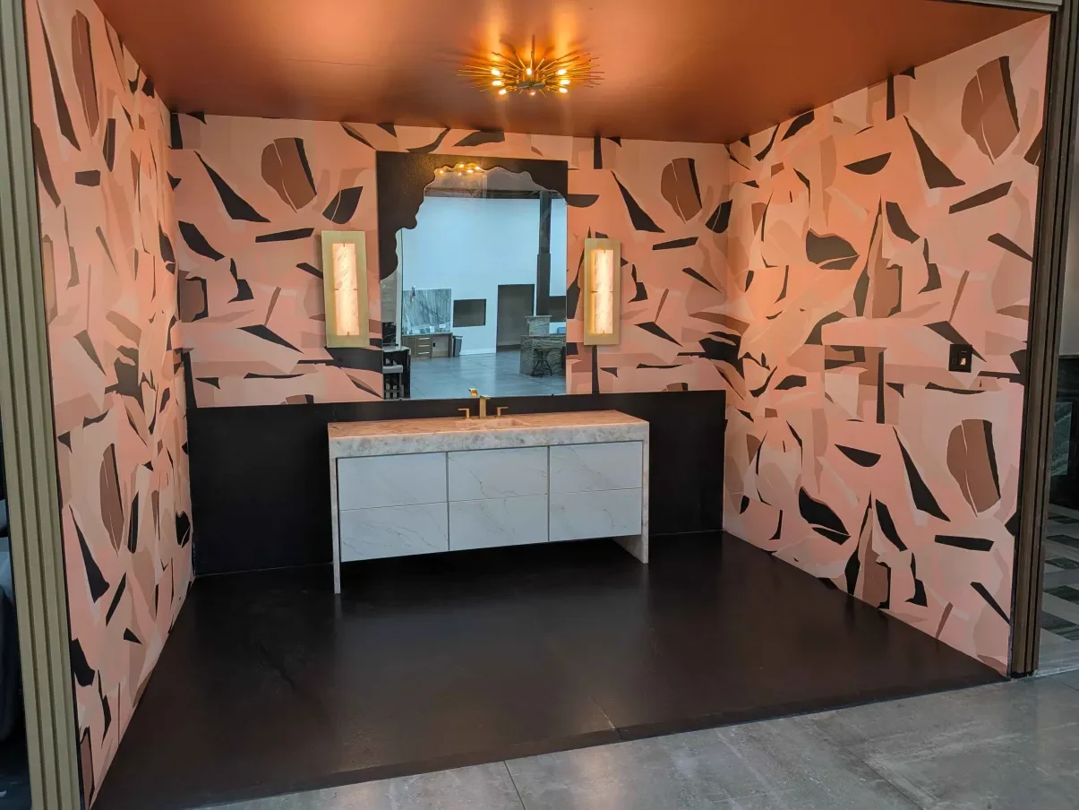 A showroom vanity room in patterned stone with a lit mirror