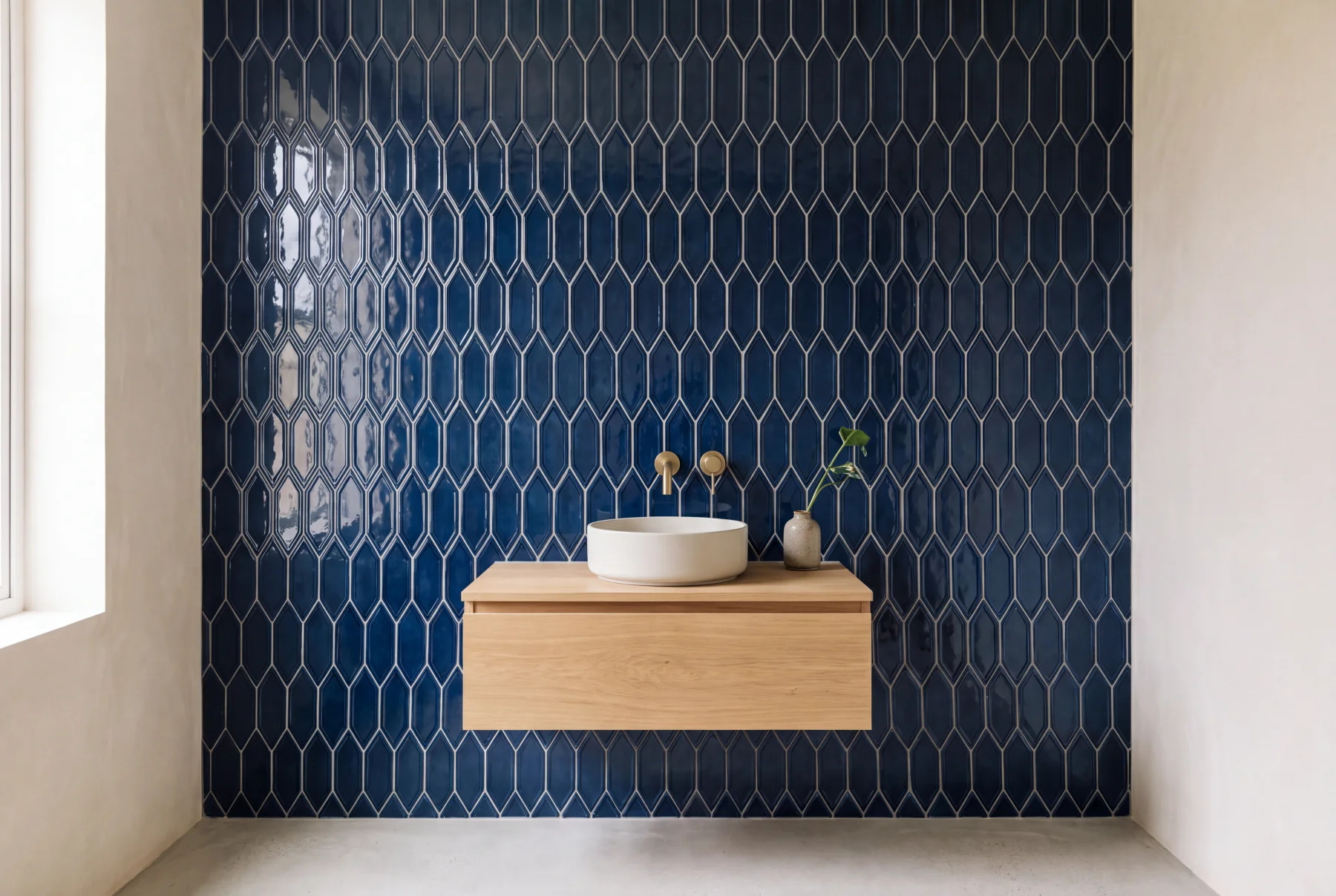 Geoscape Diamond Midnight Blue tile on a bathroom wall behind an oak vanity, visualized