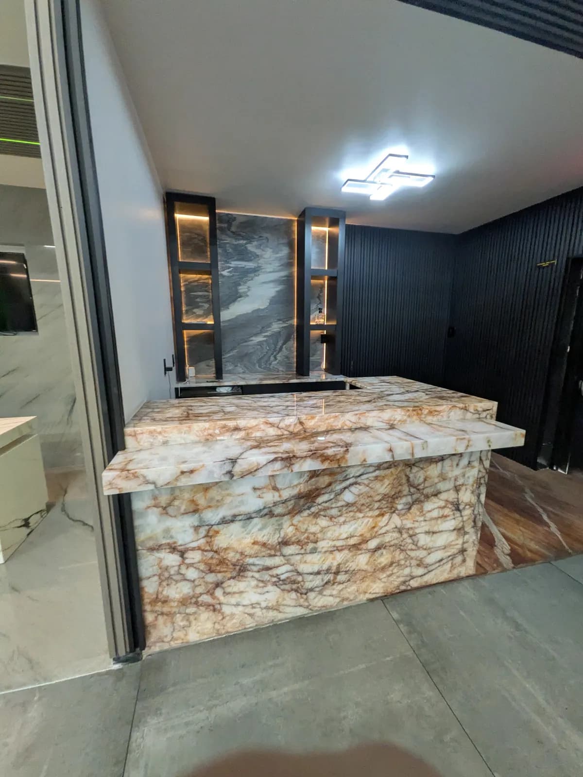 A kitchen island in white stone with rust-colored veining
