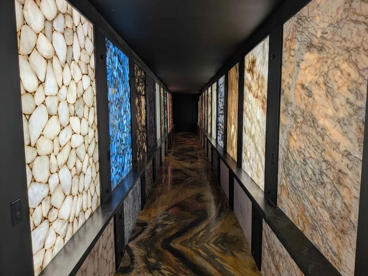 The backlit gallery at KLZ: a corridor walled with agate, quartz and marble slabs lit from behind